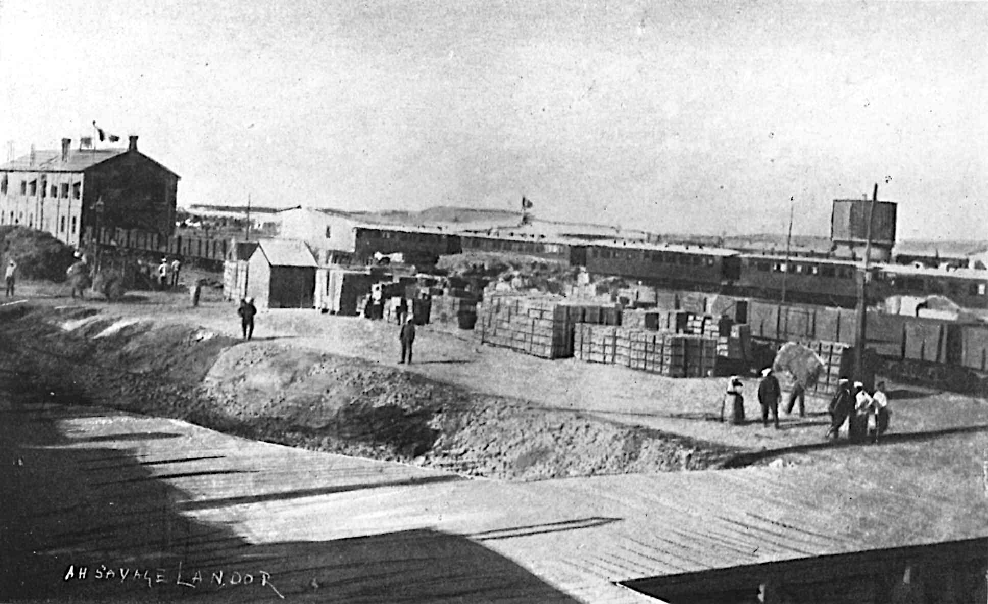 Many containers and people next to some buildings