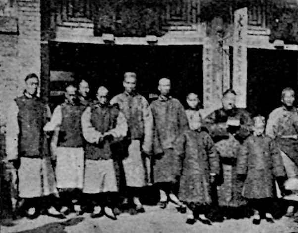 People in attire in line in front of building