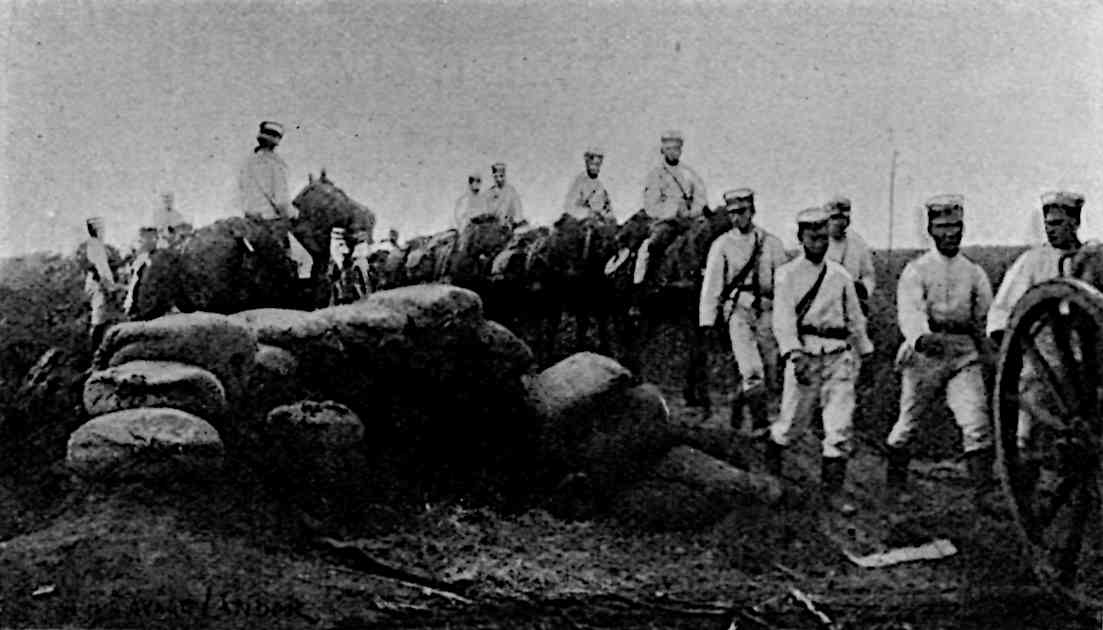 An emblacement with several soldiers walking and riding horses in line behind