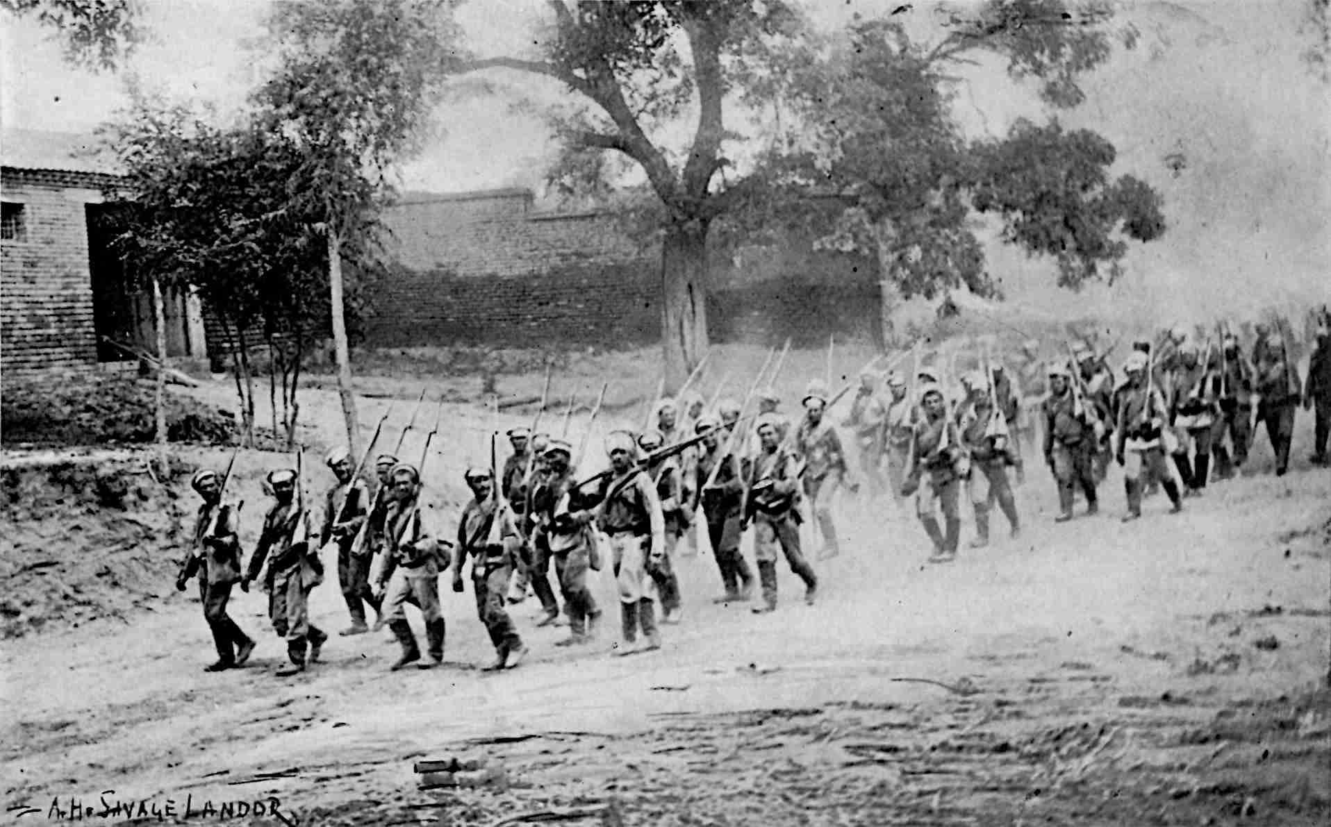 Soldiers marching in lines, with a building and trees in background