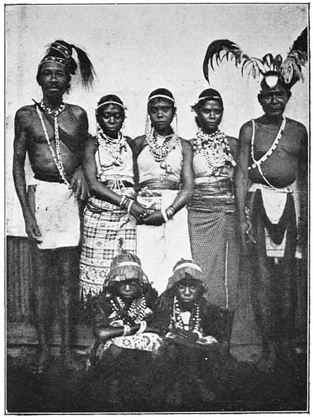 Alfoeren van Warasiwa in feestkleeding; op den voorgrond meisjes met helmen van kladibladeren.