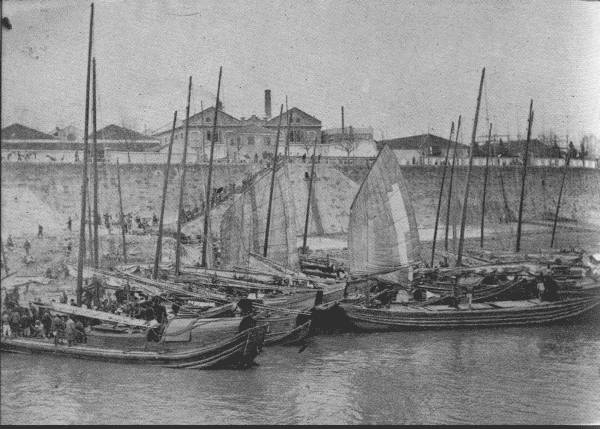 AT HANKOW—THE CHICAGO OF CHINA

River-front scene at low water, showing junks that transport general
cargo down-river from the exporting districts. This is a typical
riverfront scene.