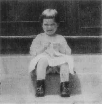 Young Child Sitting in Boots and White Dress
