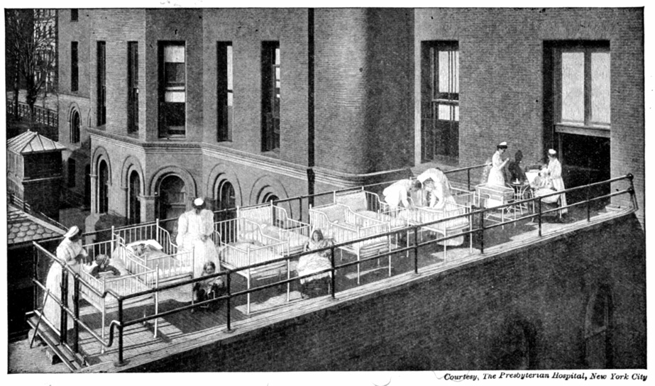 Hospital beds outdoors on the ledge of a building.