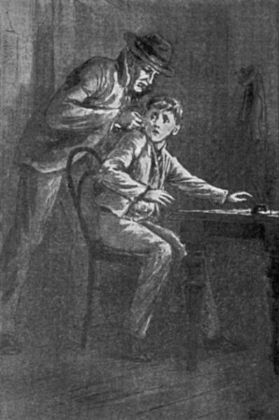 A boy sits at a table in a darkened room. An older man, wearing
a suit and hat, holds the boy firmly by the ear.