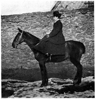 Woman mounted, showing fit of coat