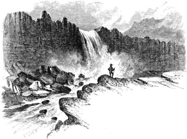 A waterfall pours over the top of the cliff