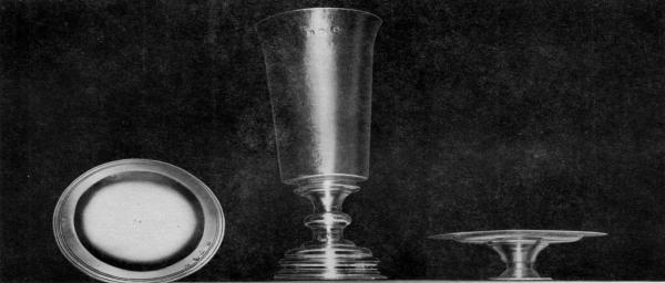 COMMUNION SERVICE IN USE AT SMITH'S HUNDRED, 1618.

This three piece communion service now at St. John's Church, Elizabeth City Parish, Hampton, Virginia,
has the longest history of use in the United States of any church silver. The set, a gift to the church founded
in 1618 at Smith's Hundred in Charles City County, was made possible by a legacy in the will (date 1617) of
Mrs. Mary Robinson of London. Smith's Hundred renamed Southampton Hundred, 1620, was practically
wiped out in the Indian Massacre of 1622. This communion set delivered in 1627 to the Court at Jamestown
for safe keeping, supposedly, then was given to the second Elizabeth City Church built on Southampton (now
Hampton) River. The inscription in one line on the base of the Chalice is: The Communion Cupp for Snt
Marys Church in Smiths Hundred in Virginia. Hall marks on all three pieces bear London date-letters for
1618-19.

Courtesy Mrs. L. T. Jester and Mrs. P. W. Hiden