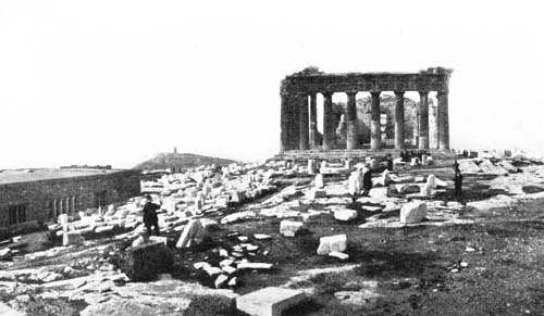 ACROSS THE SUMMIT OF THE ACROPOLIS, TRAMPLING OVER FRAGMENTS OF DECORATIONS.