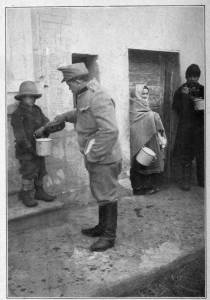 Photograph from Henry Ruschin
AUSTRIAN SOLDIER IN CARPATHIANS GIVING HUNGRY YOUNGSTER
SOMETHING TO EAT
Moved by the misery of the civilian population the soldiers will often share their
rations with them. An Austrian soldier in this case shares his food with a boy in a
small town in the Carpathian Mountains, Hungary.