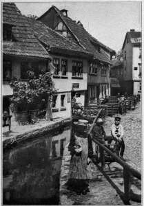Copyright by Underwood & Underwood, N. Y.
STREET SCENE AT EISENBACH, SOUTHERN GERMANY
From the villages and small towns is recruited sixty per cent. of the German army.