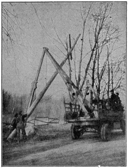 Erecting telephone pole with motor-truck derrick