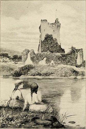 Girls sitting by lake with ruin of a castle across from them