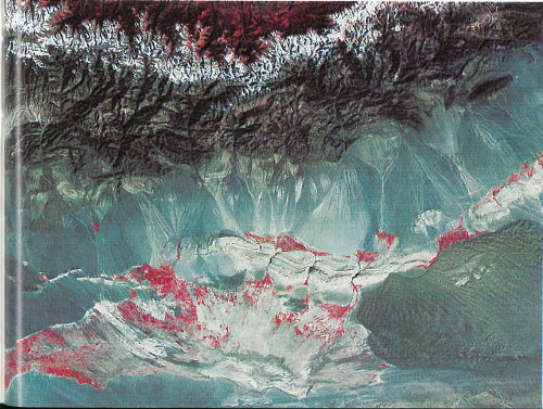 This Landsat image shows the Turpan Depression in the rain shadow desert of the Tian Shan of China. A sand sea is in the lower center on the right, but desert pavement, gray in color, dominates this desert. The few oases in the desert and the vegetation in the mountains at the top are in red. A blanket of snow separates the vegetation in the Tian Shan from the rain shadow desert.