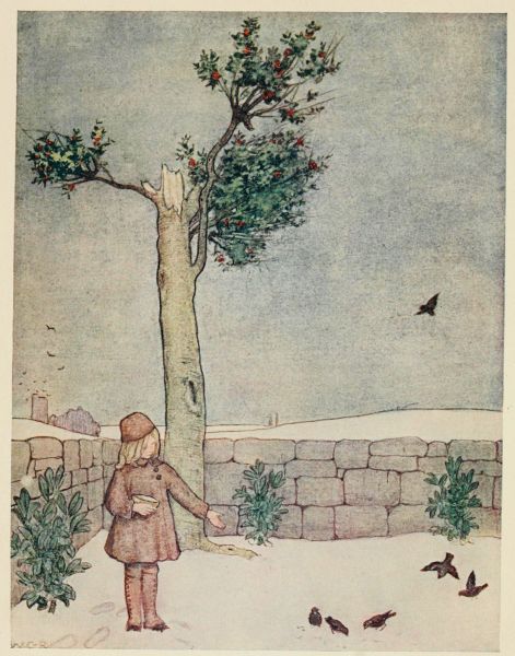 girl feeding birds in garden in winter