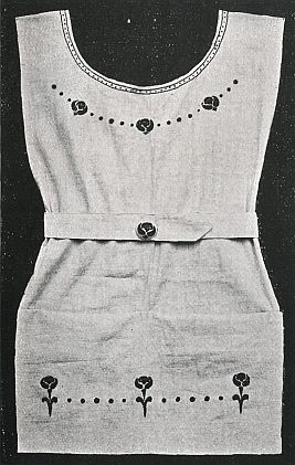 full short apron with embroidery around neck and hem with waistband held iwth decorative button in front