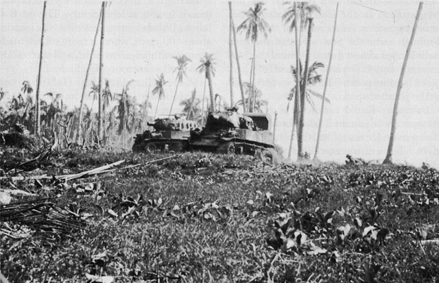 75-MM. M8 SELF-PROPELLED HOWITZERS move in to support the infantrymen in their advance from the beach.