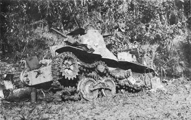 JAPANESE LIGHT TANK destroyed during the fighting along Highway 2. Note dugouts in the sides of banks behind the tank.