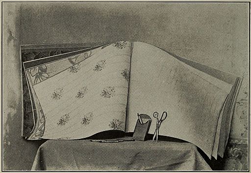 photograph: wallpaper book, crayons, scissors on a table