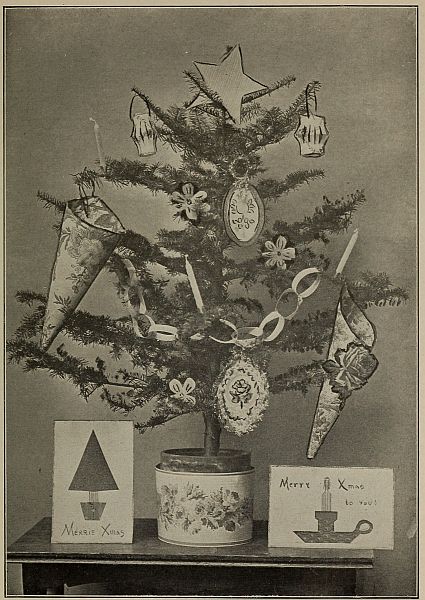 photograph of small Christmas tree decorated with two cards beneath