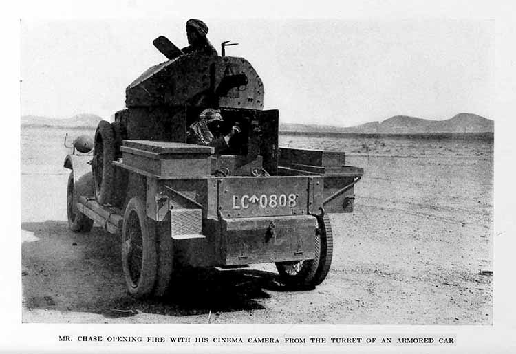 Photograph: MR. CHASE OPENING FIRE WITH HIS CINEMA CAMERA FROM THE TURRET OF AN ARMORED CAR