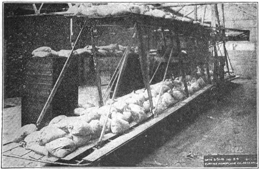 Fig. 10a. Testing the Wing Structure of a Curtiss Biplane by Means of Sand Bag Loading.